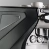 Closeup front-side view of the Rancilio Classe 5 espresso machine steam wand, steam c-lever, gauges and side panels. 